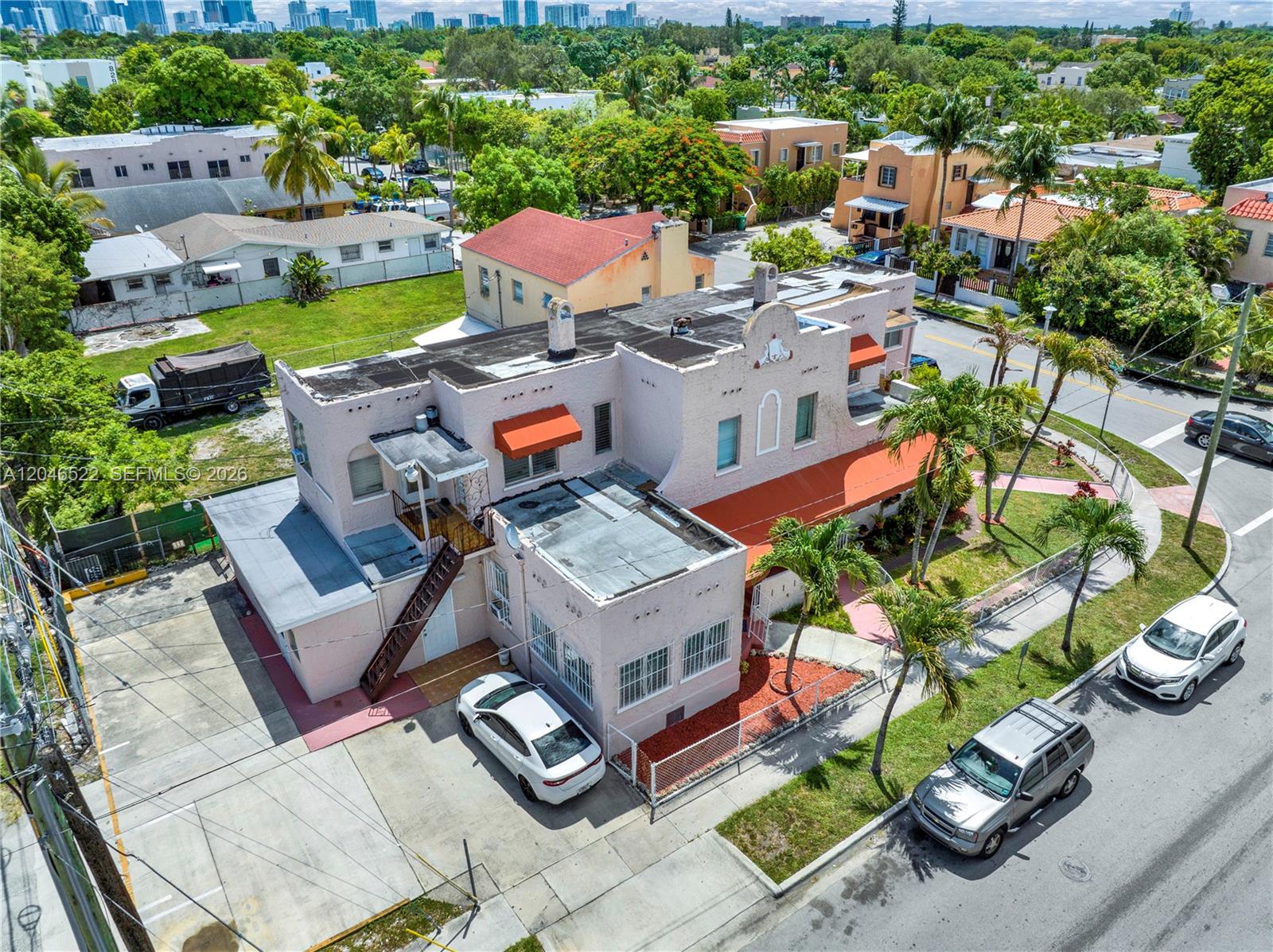 An aerial view shows a pink multi-story building with a flat roof and parking area — 829 SW 19th Ave, Miami FL 33135, MIAMI, FL