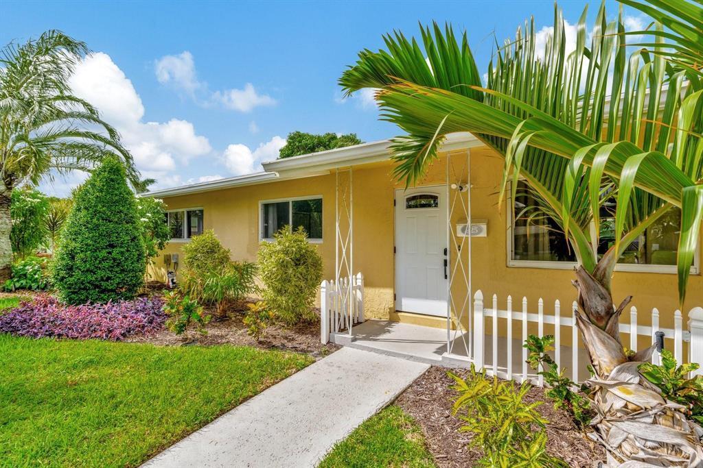 A yellow single-story house features a white front door, a walkway, and palm trees — 925 NE 25th Avenue, Pompano Beach FL 33062, POMPANO BEACH, FL