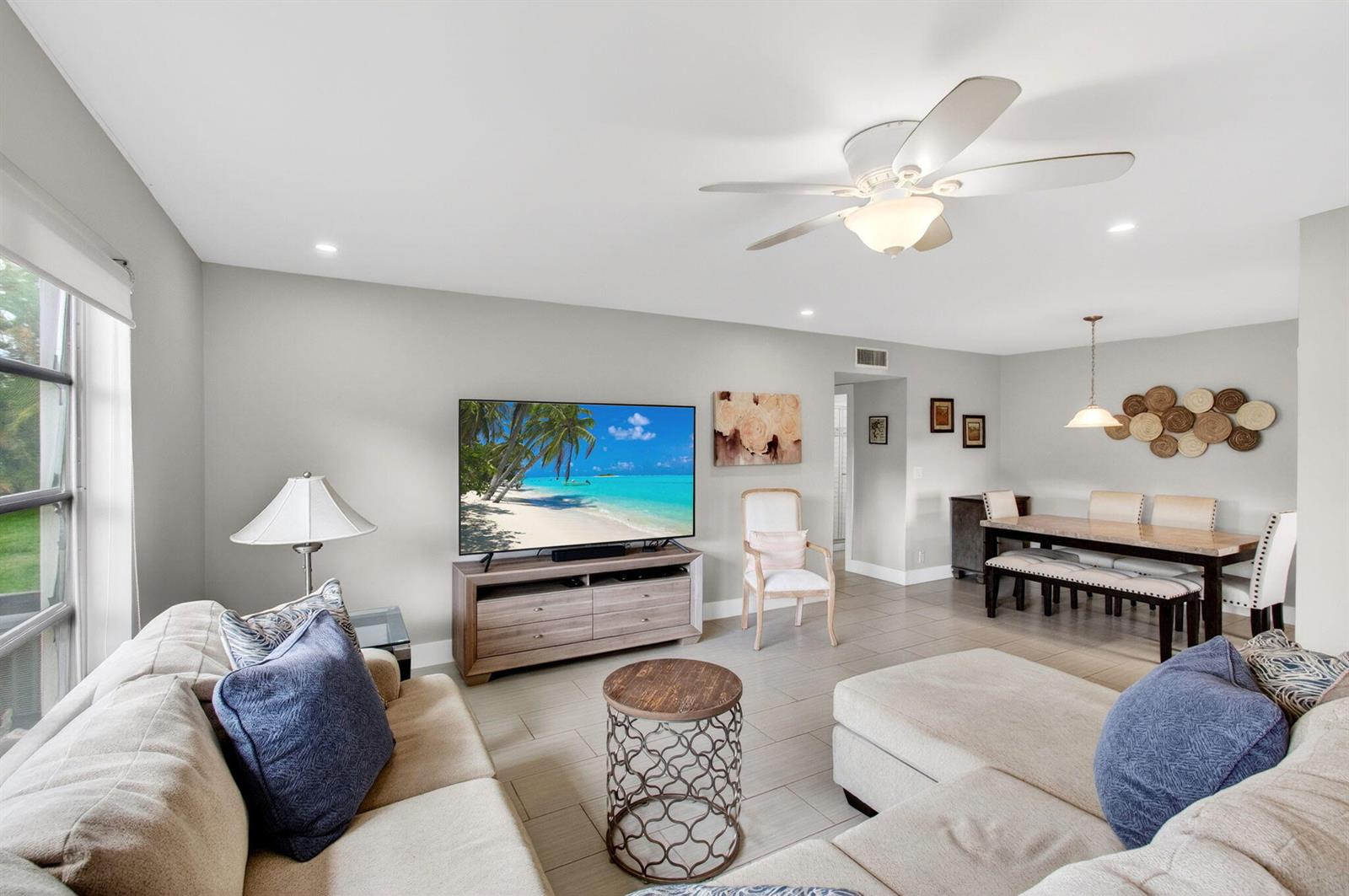 A living room and dining area with light tile floors, a sectional sofa, and television — 5250 NW 3rd Court # A, Delray Beach FL 33445, DELRAY BEACH, FL