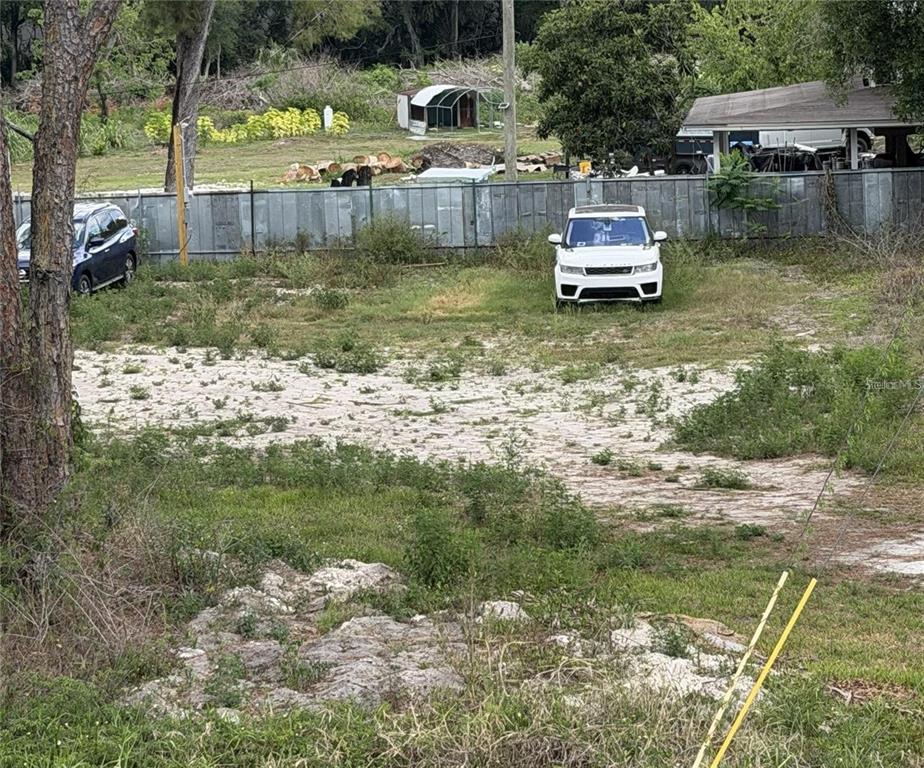 A vacant, sandy lot features a white SUV parked near a metal fence — 6806 NEW YORK DRIVE Lots A,B,C, TAMPA, FL