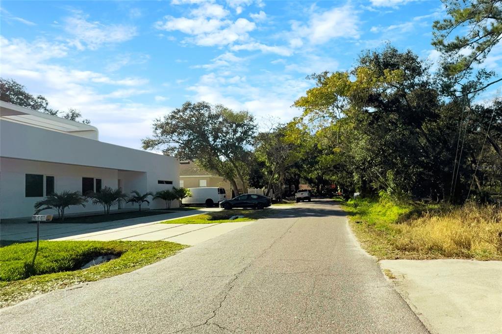 A modern white house sits on a residential street with trees and parked cars — 6806 NEW YORK DRIVE Lots A,B,C, TAMPA, FL