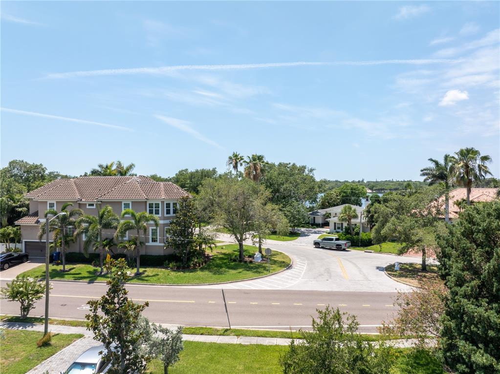 An elevated view shows a suburban street intersection with houses, palm trees, and greenery — 167 ALMEDO WAY NE, ST PETERSBURG, FL