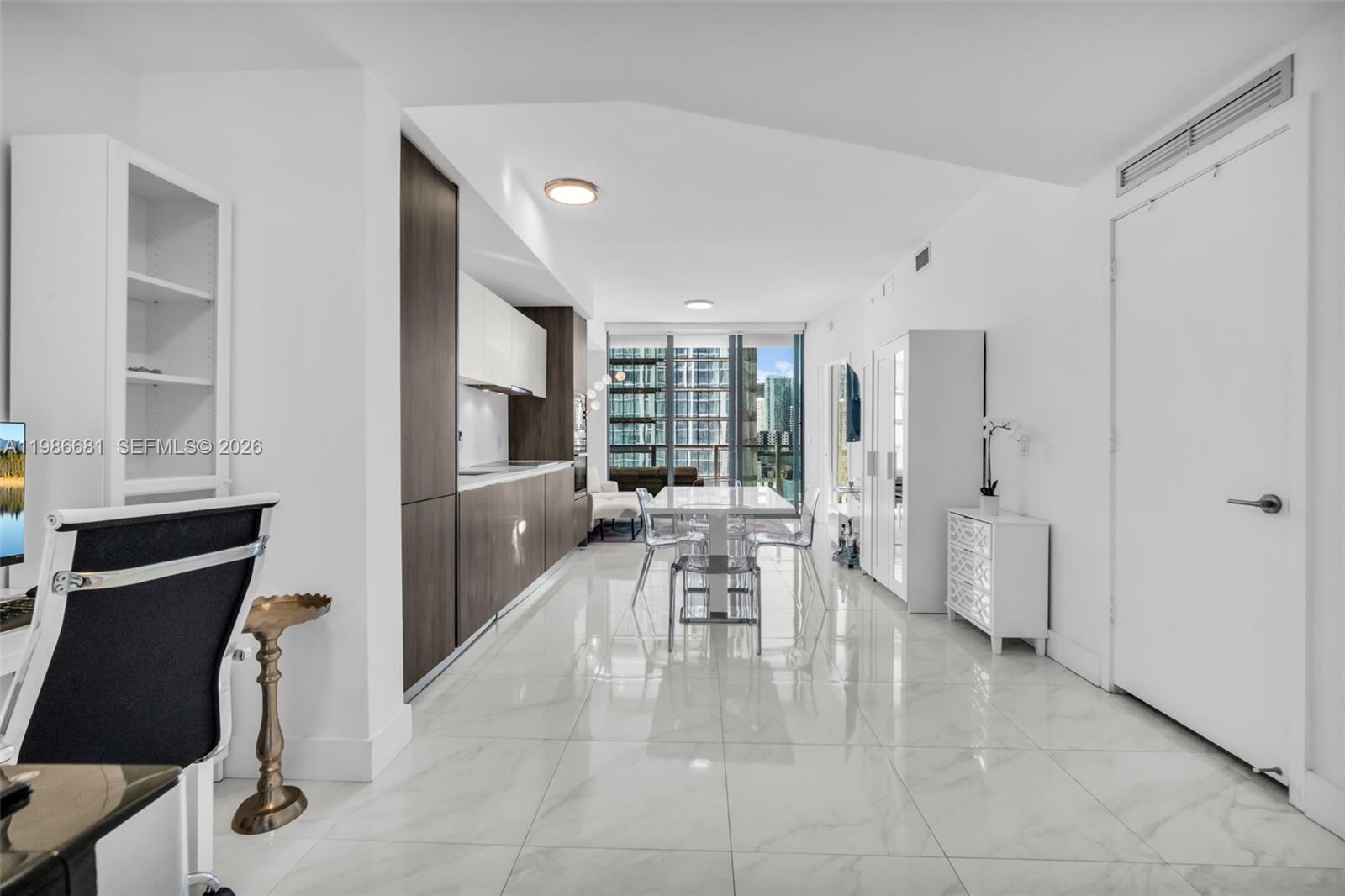 A modern kitchen and dining area with white tile floors and dark wood cabinetry — 2900 NE 7th Ave # 1408, Miami FL 33137, MIAMI, FL