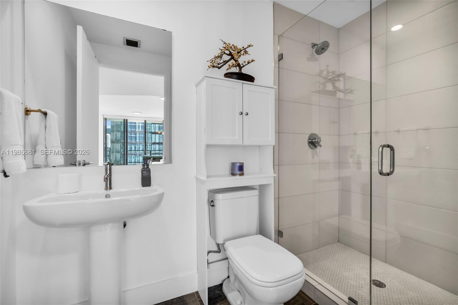 A bathroom features a pedestal sink, a toilet with an over-the-toilet cabinet, and a glass-enclosed shower — 2900 NE 7th Ave # 1408, Miami FL 33137, MIAMI, FL