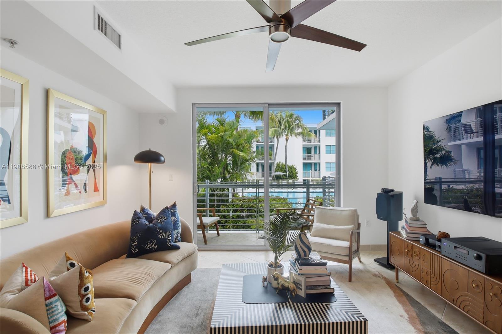 A living room features a beige sofa, patterned coffee table, and sliding doors to a balcony — 110 Washington Ave # 2420, Miami Beach FL 33139, MIAMI BEACH, FL
