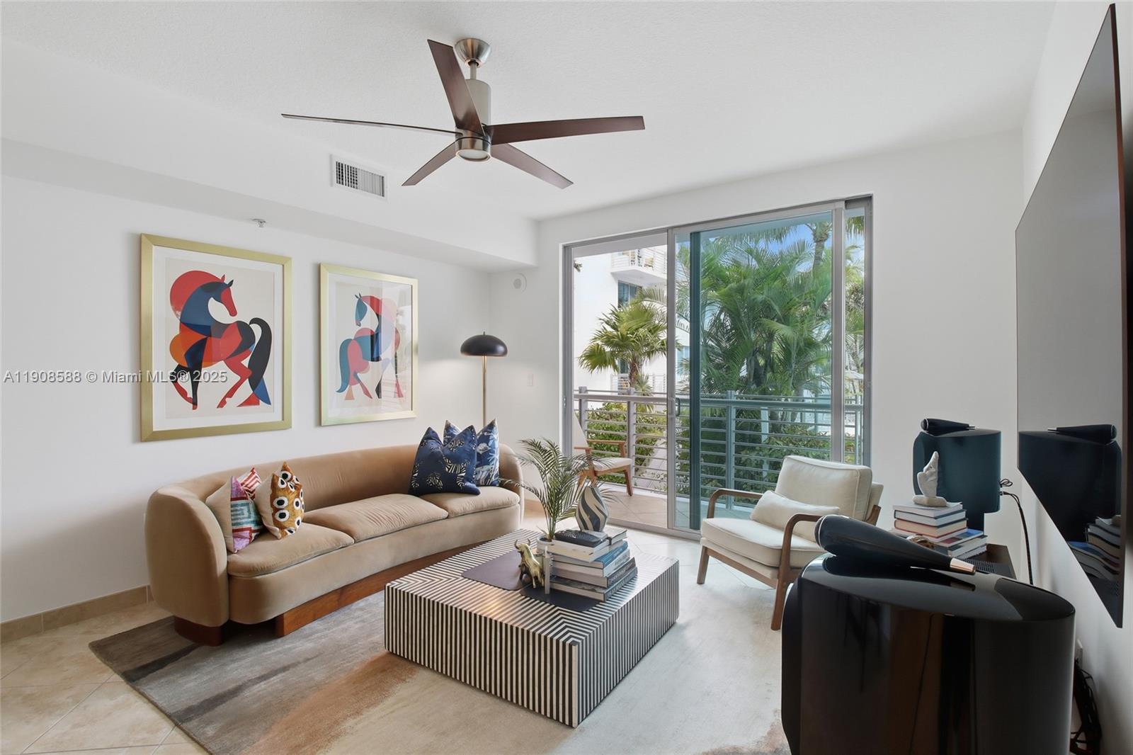 A modern living room features a beige sofa, striped coffee table, and a balcony view — 110 Washington Ave # 2420, Miami Beach FL 33139, MIAMI BEACH, FL