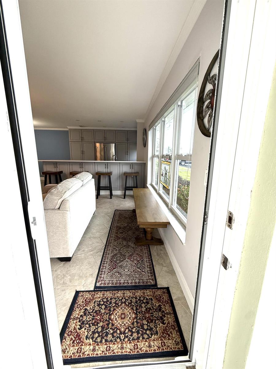 A view from a doorway into a living area with a kitchen island and bench — 916 Savannas Point Drive, Fort Pierce FL 34982, FORT PIERCE, FL