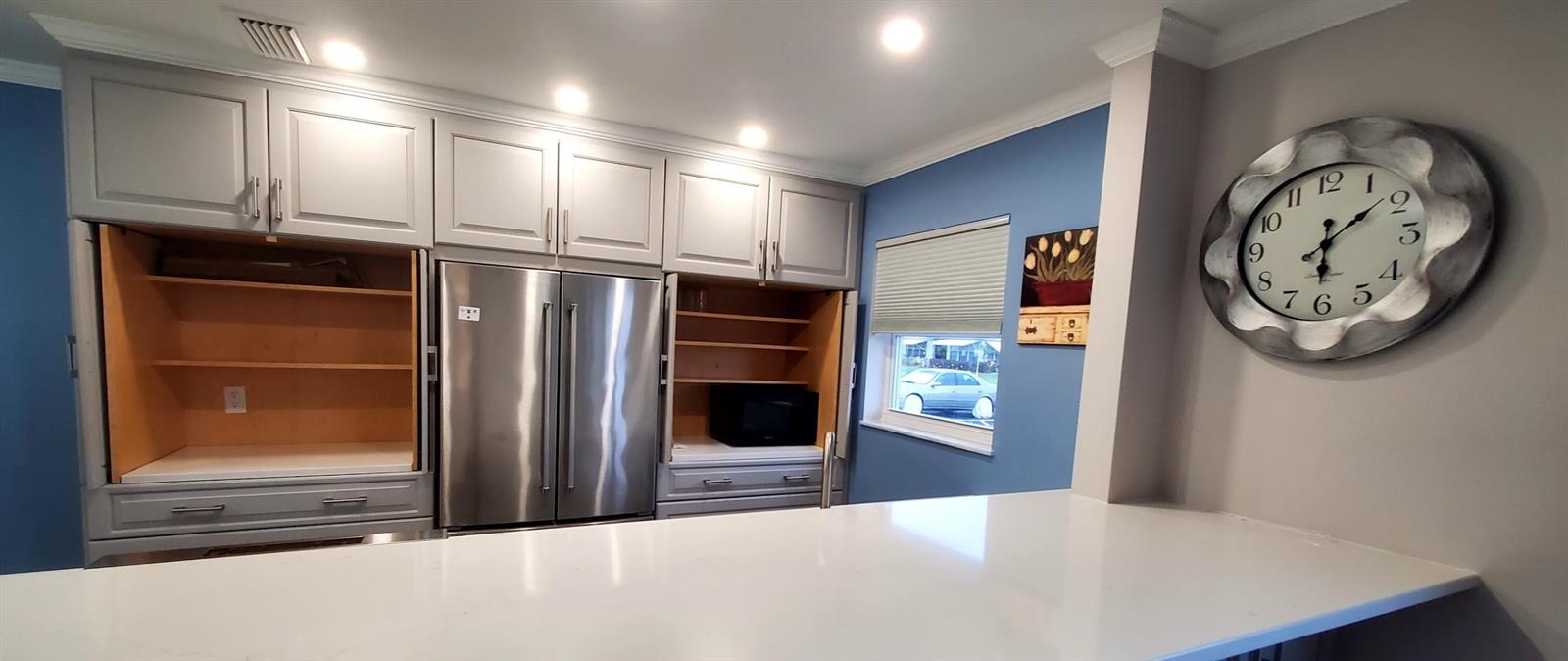 A kitchen features light gray cabinets, stainless steel appliances, a white countertop, and blue walls — 916 Savannas Point Drive, Fort Pierce FL 34982, FORT PIERCE, FL