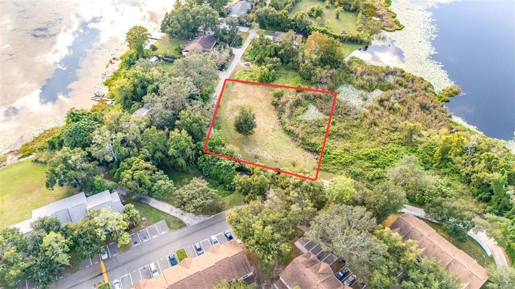 An aerial view shows a vacant, rectangular lot outlined in red between two bodies of water — RIVERSIDE PARK ROAD, ORLANDO, FL