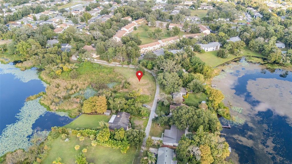An aerial view shows a vacant lot marked by a red pin near a lake — RIVERSIDE PARK ROAD, ORLANDO, FL