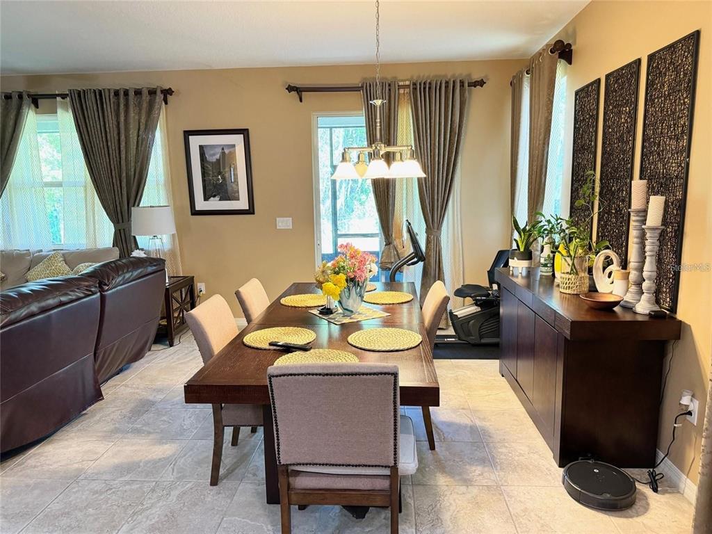 A dining room features a dark wood table, upholstered chairs, and a matching sideboard — 11460 WAKEWORTH STREET, ORLANDO, FL