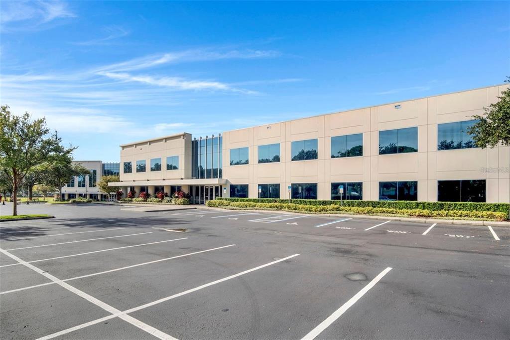 A multi-story office building with a large parking lot in the foreground — 6200 METROWEST BOULEVARD UNIT 103B, ORLANDO, FL