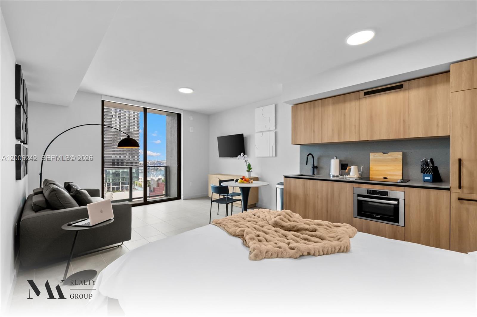A studio apartment features a kitchen, living area, and bed with a balcony view — 121 NE 5 # 2700, Miami FL 33132, MIAMI, FL