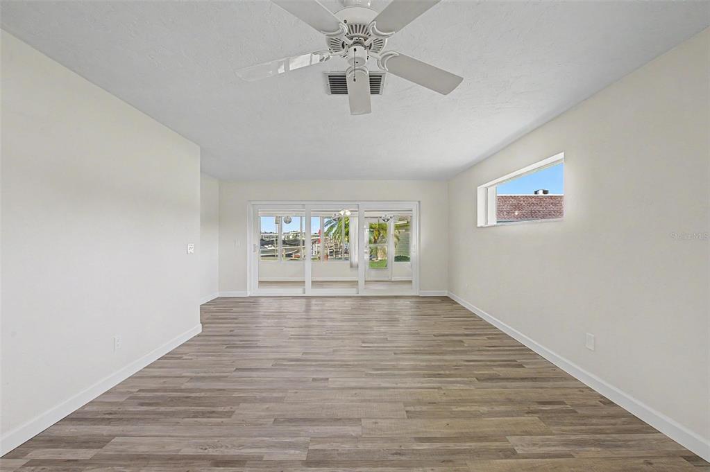A kitchen with white cabinets, gray subway tile backsplash, quartz countertops, and a sliding glass door — 144 BOCA CIEGA POINT BOULEVARD N, ST PETERSBURG, FL
