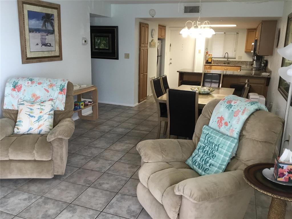 A living room with two tan recliners leads to a dining area and open kitchen — 1571 S ATLANTIC AVENUE UNIT 406, NEW SMYRNA BEACH, FL