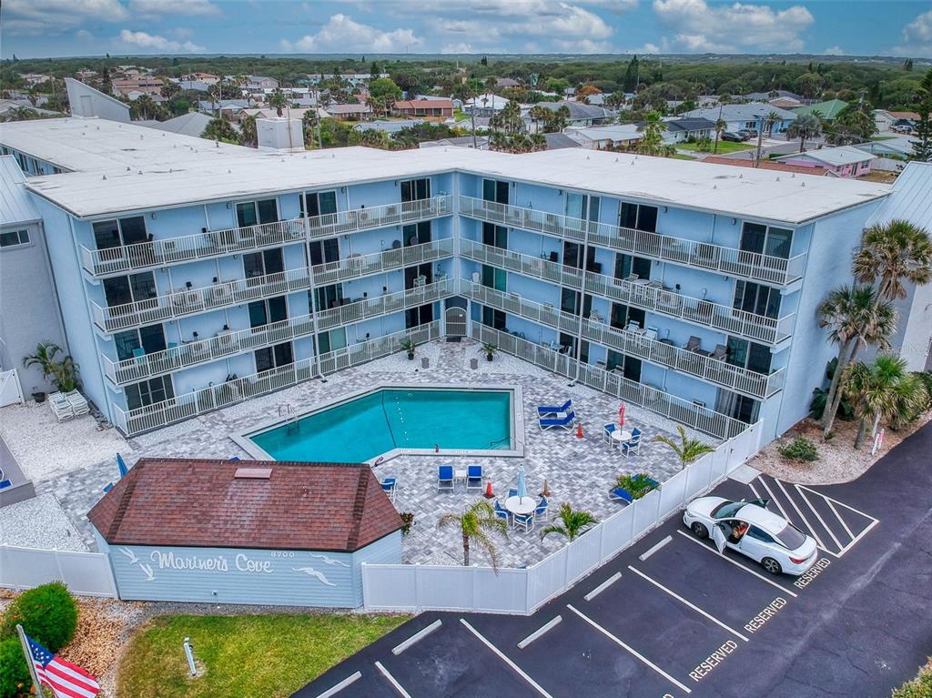 An aerial view of a blue multi-story apartment building with a central swimming pool — 3700 S ATLANTIC AVENUE UNIT 103, NEW SMYRNA BEACH, FL