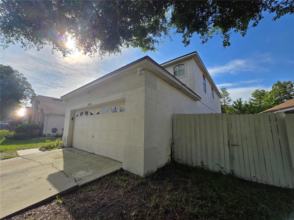 A two-story house with a white stucco exterior and a two-car garage — 12018 GRECO, ORLANDO, FL