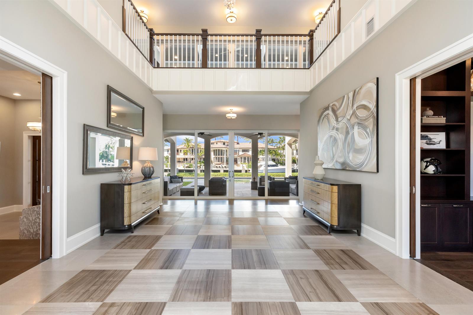 A grand foyer features a checkered tile floor, dual consoles, and a view of the patio — 3211 NE 27th Avenue, Lighthouse Point FL 33064, LIGHTHOUSE POINT, FL