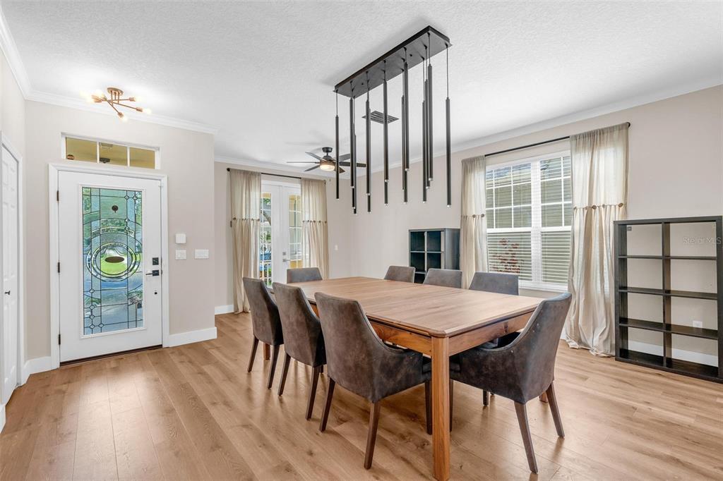 A dining room features a wooden table, six gray chairs, and a modern pendant light — 13842 ORANGE CREST DRIVE, WINDERMERE, FL