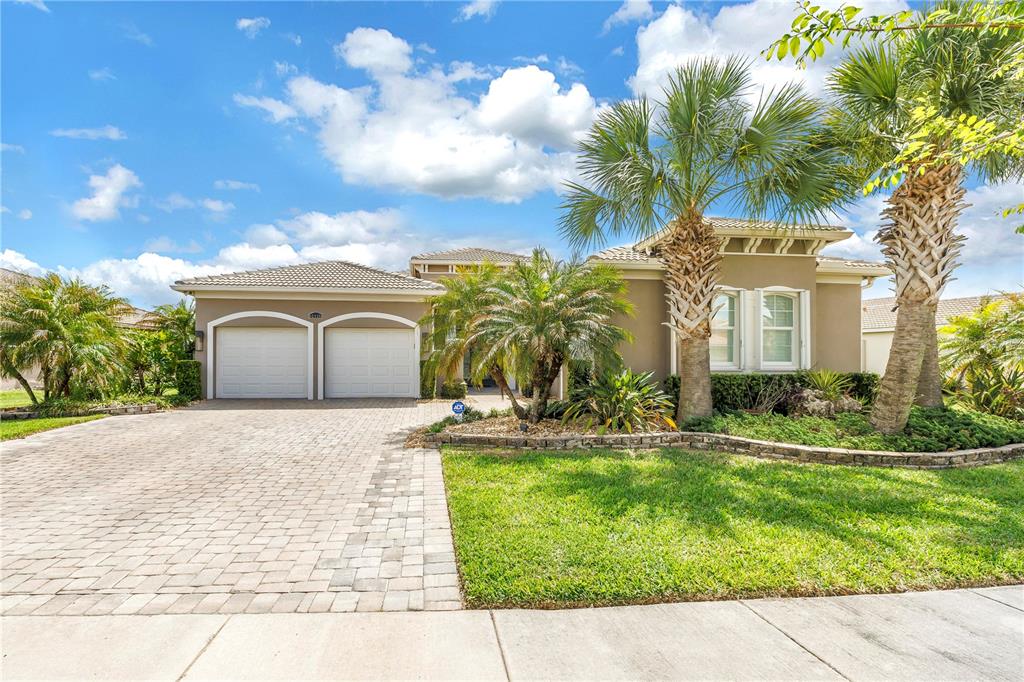 A single-story house with a two-car garage, palm trees, and a paved driveway — 15939 CAPE CORAL DRIVE, WIMAUMA, FL
