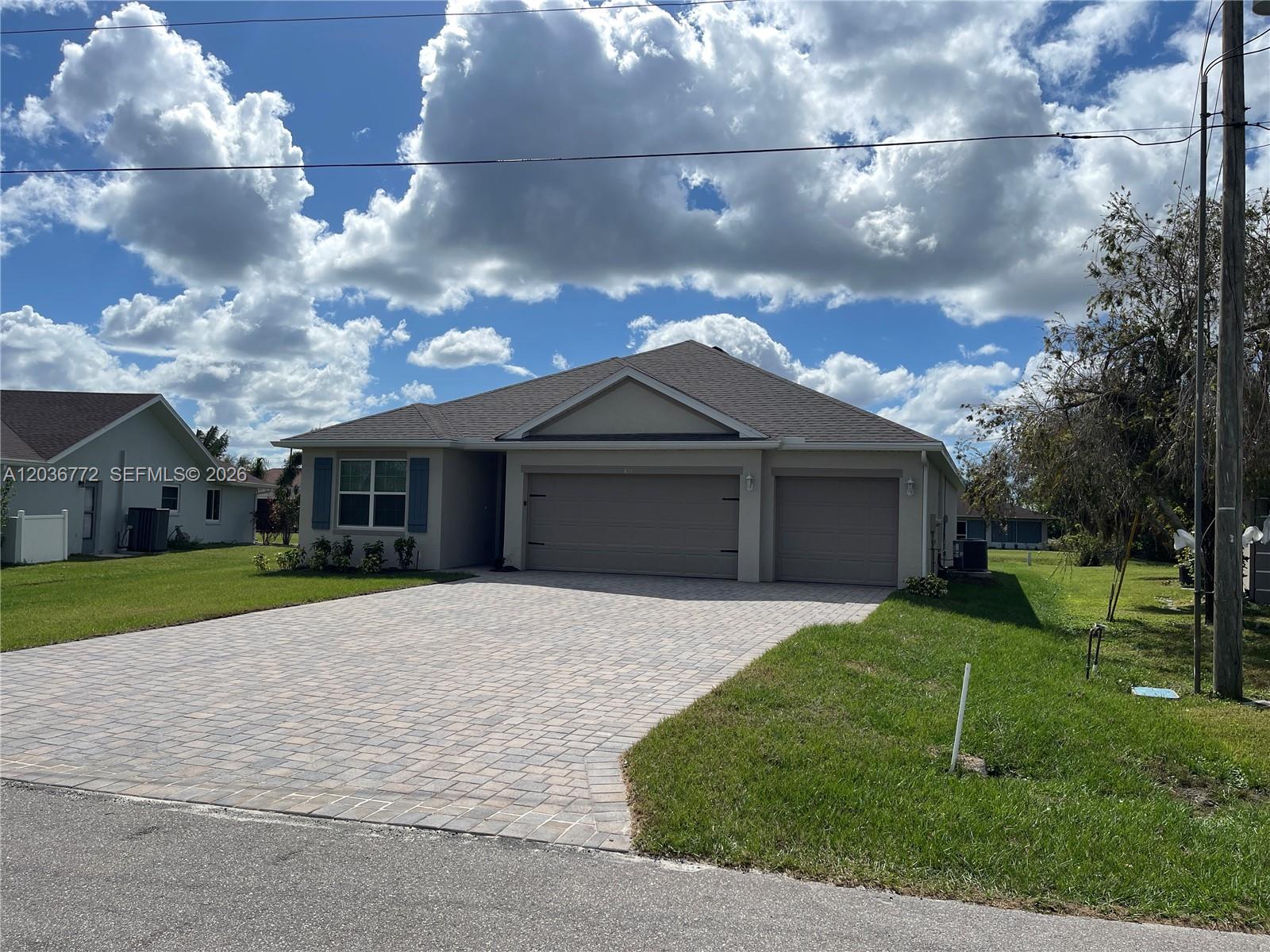 A single-story house with a paved driveway, a three-car garage, and a tan exterior — 455 Londrina Dr, Punta Gorda FL 33983, PUNTA GORDA, FL
