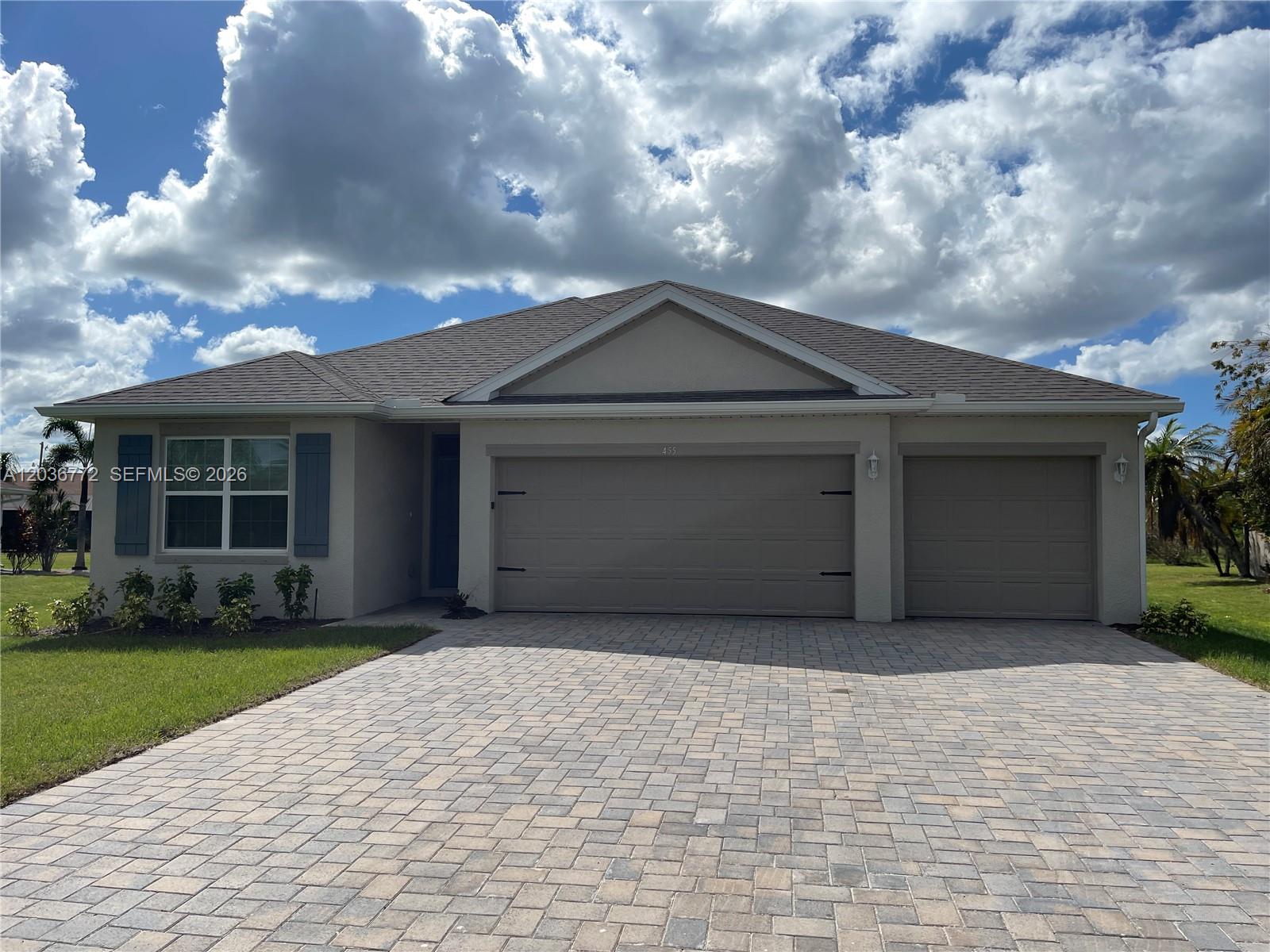 A single-story house with a paved driveway, two garage doors, and a front lawn — 455 Londrina Dr, Punta Gorda FL 33983, PUNTA GORDA, FL