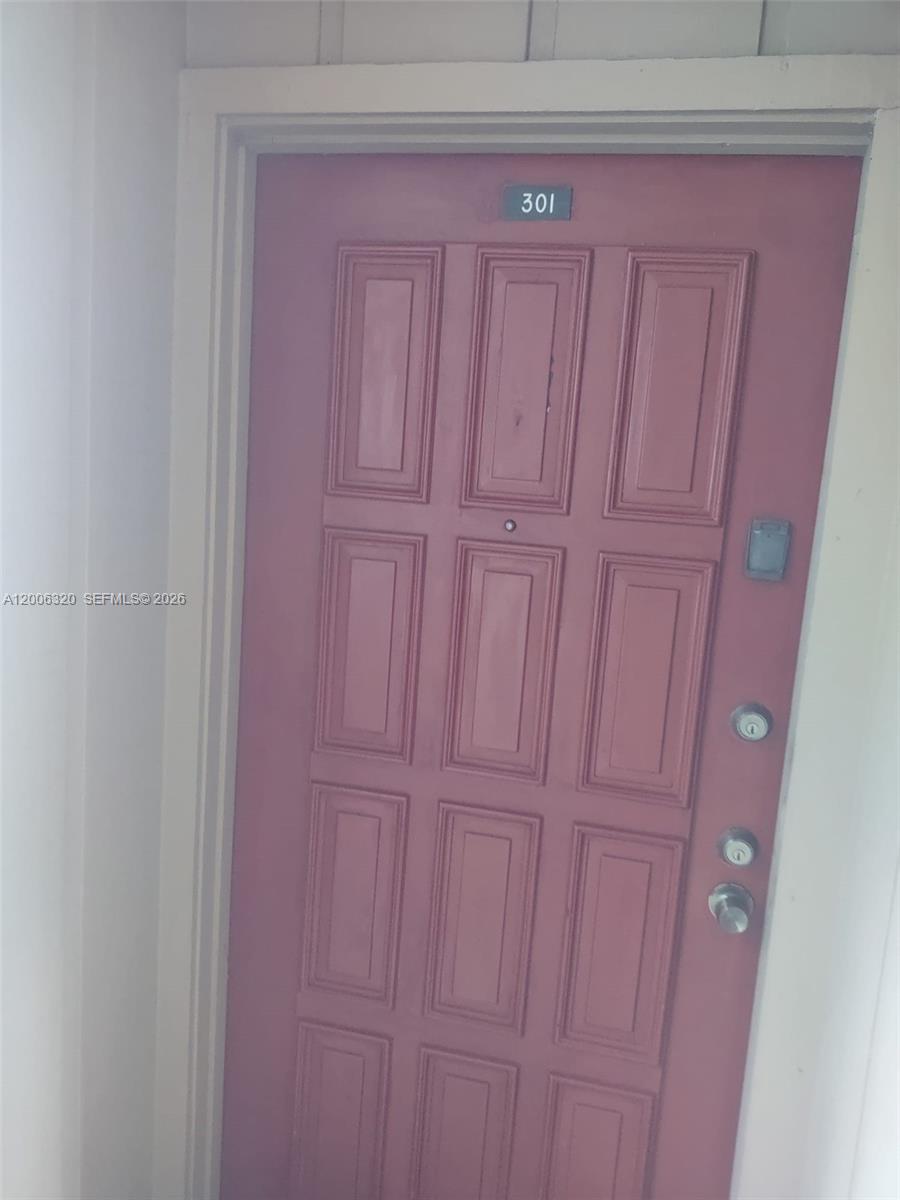 A pink, six-panel door with the number 301 is set within a white door frame — 10625 SW 112th Ave # 301, Miami FL 33176, MIAMI, FL