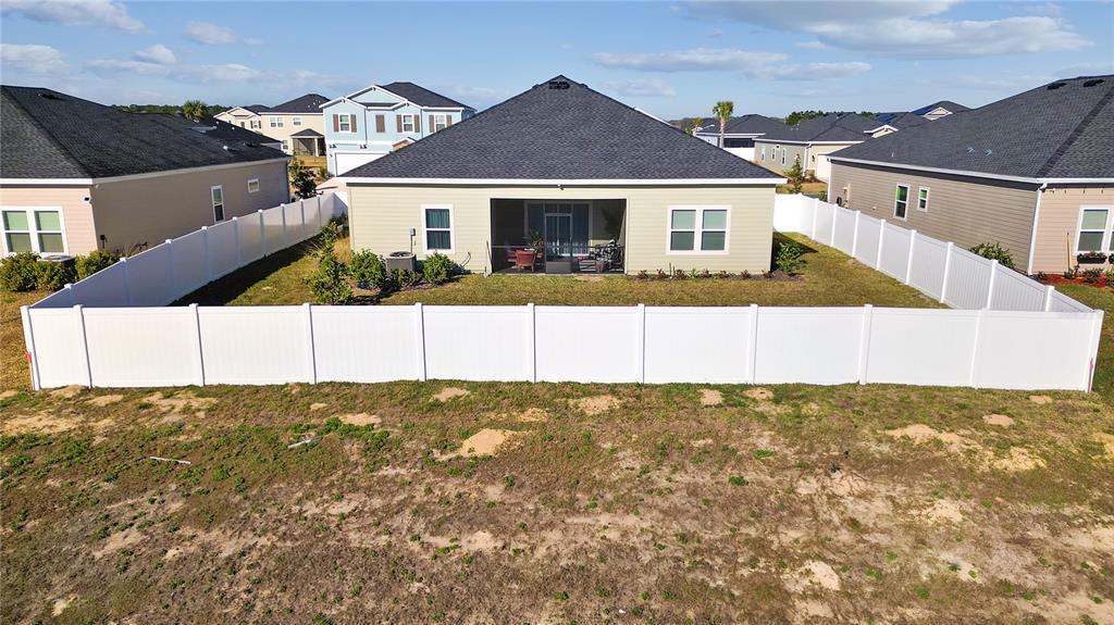 An aerial view shows the backyard and rear exterior of a single-story house with a fence — 9191 SW 57TH TERRACE, OCALA, FL