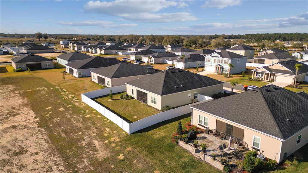 An aerial view shows a suburban neighborhood with several single-family homes and fenced backyards — 9191 SW 57TH TERRACE, OCALA, FL