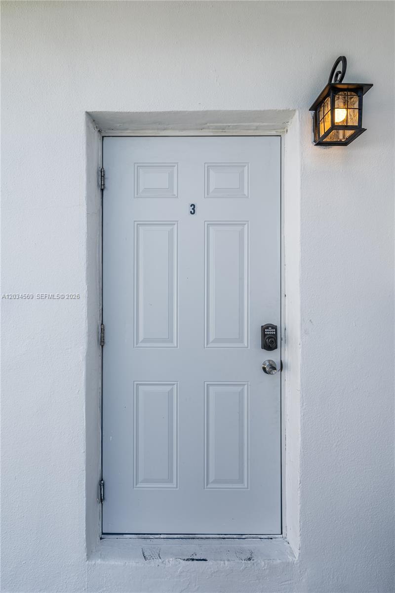 A white exterior door labeled with the number three features a black electronic lock — 105 SW 5th Ct, Dania Beach FL 33004, DANIA BEACH, FL