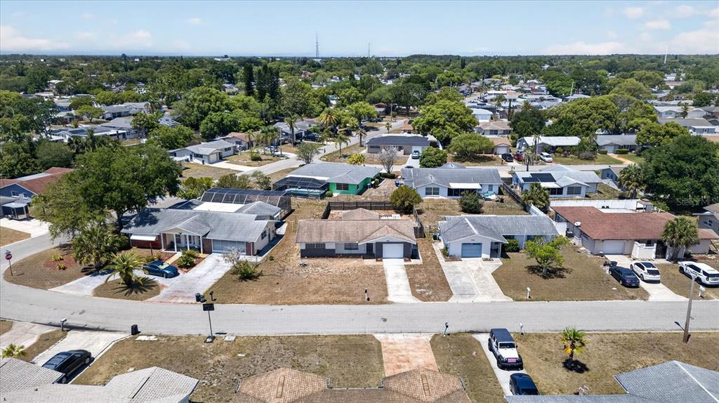 An aerial view of a suburban neighborhood featuring single-story houses with driveways and lawns — 7523 BRIARWOOD DRIVE, PORT RICHEY, FL