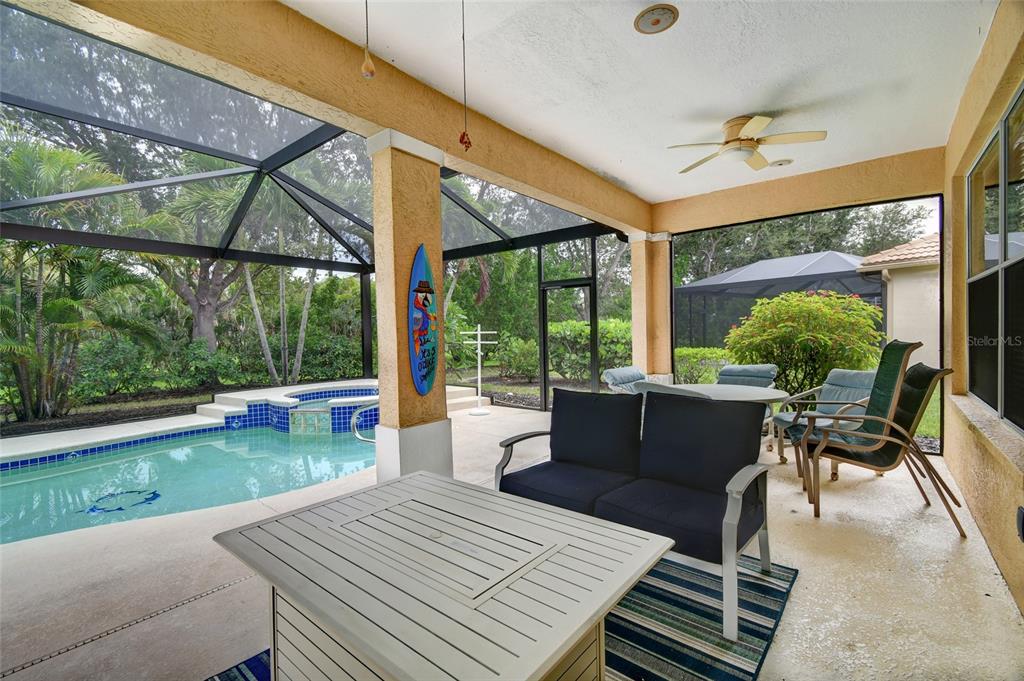 A screened-in patio features a swimming pool, a hot tub, and outdoor furniture — 17899 COURTSIDE LANDINGS CIRCLE, PUNTA GORDA, FL