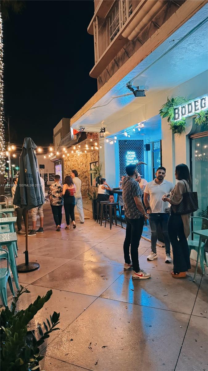 People gather on a sidewalk patio outside a restaurant at night with string lights — 1014 71st St, Miami Beach FL 33141, MIAMI BEACH, FL