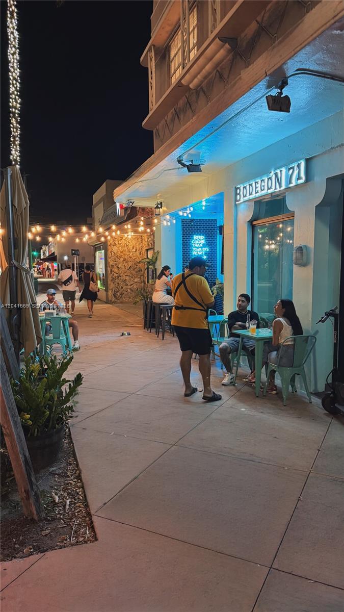 An outdoor sidewalk seating area at night in front of a restaurant named Bodegon 71 — 1014 71st St, Miami Beach FL 33141, MIAMI BEACH, FL