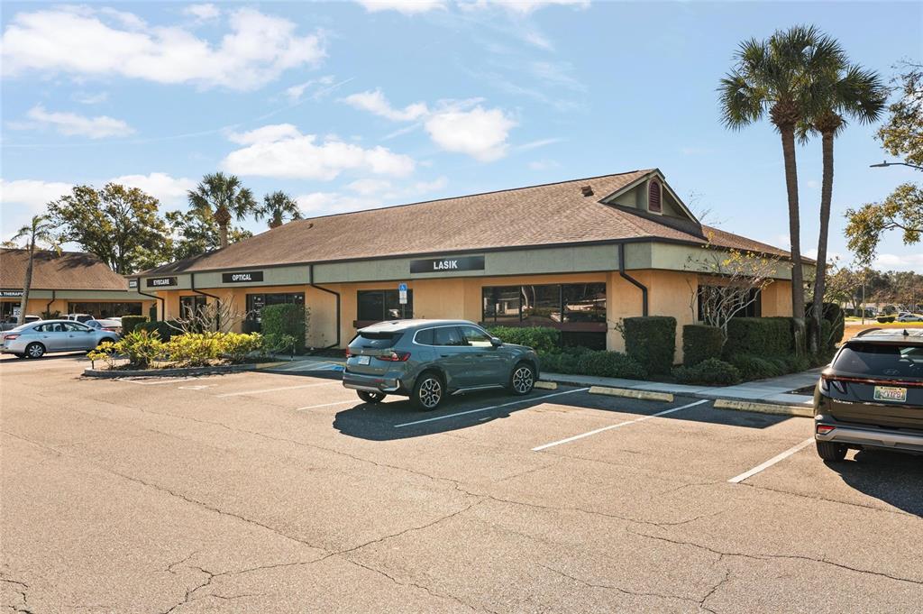 A one-story commercial building with an optical center and LASIK signage in a parking lot — 2339 SUNSET POINT ROAD UNIT C300-C302, CLEARWATER, FL