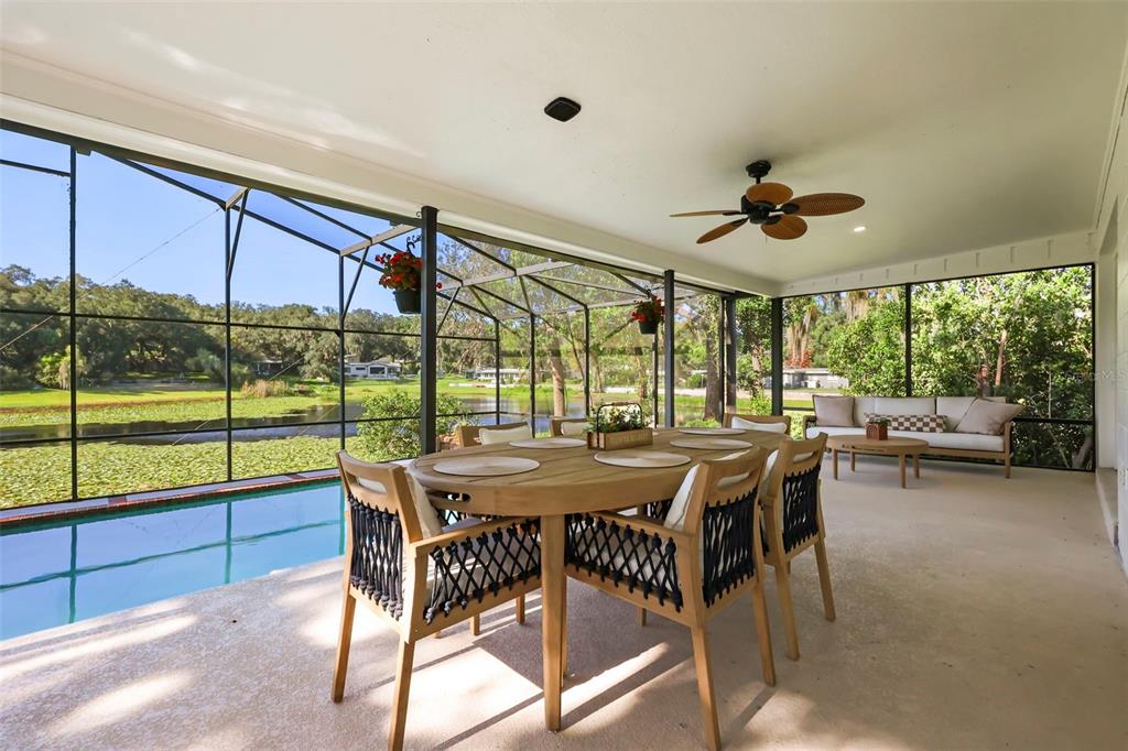 A screened-in patio features a dining set, a sofa, and a view of a pool — 1301 DRUID ISLE ROAD, MAITLAND, FL