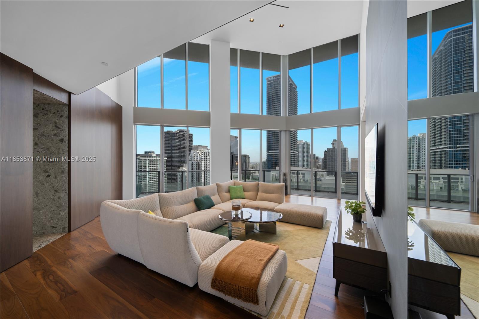 A modern living room features a large sectional sofa, floor-to-ceiling windows, and city views — 1300 Brickell Bay Dr # 4401, Miami FL 33131, MIAMI, FL