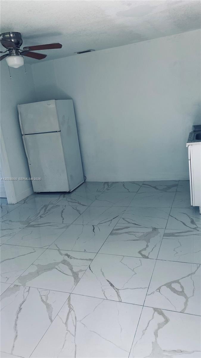A kitchen area features white marble-patterned tile flooring, a white refrigerator, and a ceiling fan — 1120 NW 147th St # 0, Miami FL 33168, MIAMI, FL