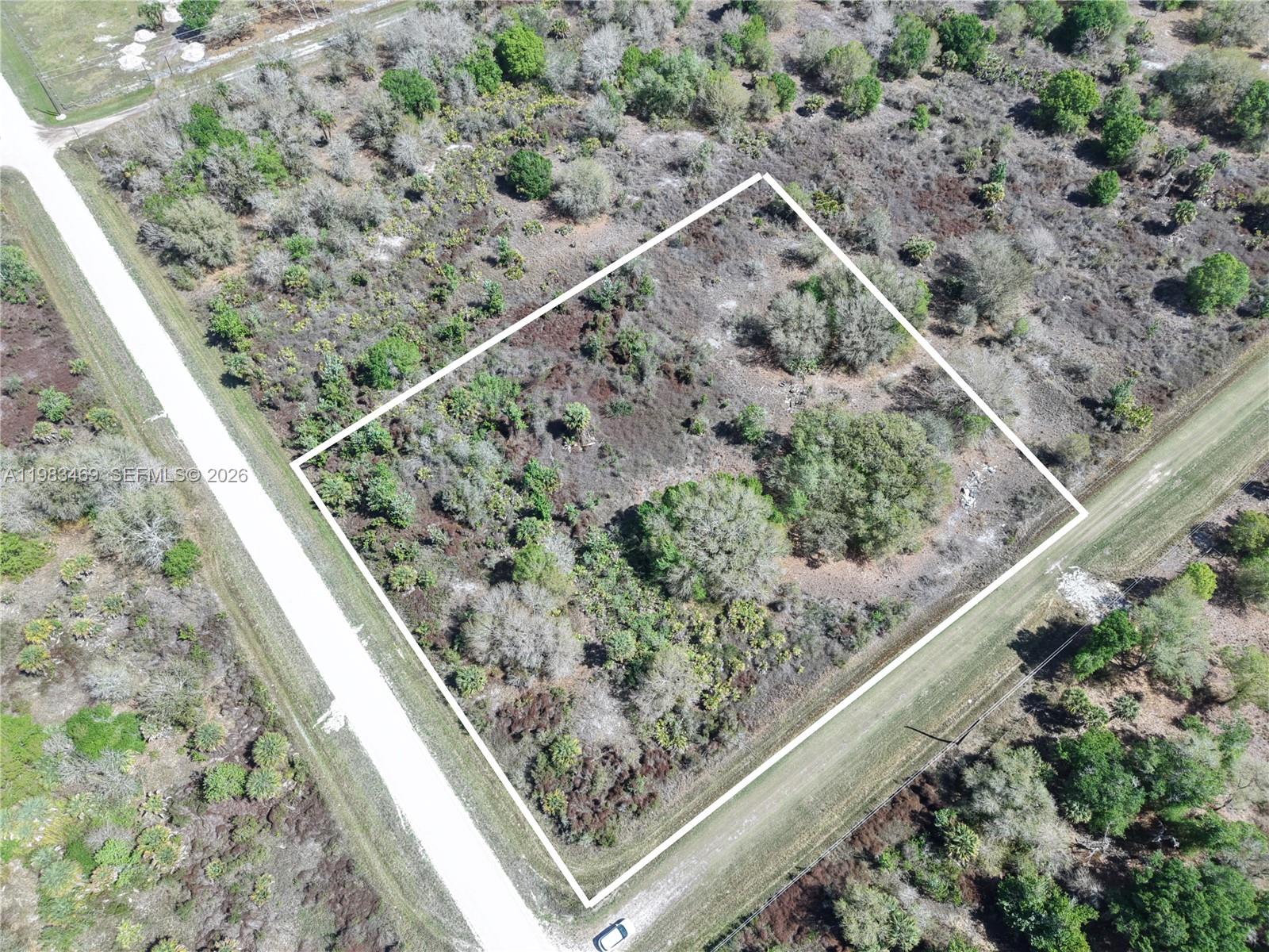 An aerial view shows a rectangular plot of land outlined in white between two roads — 20755 NW 262ND, Okeechobee FL 34972, OKEECHOBEE, FL