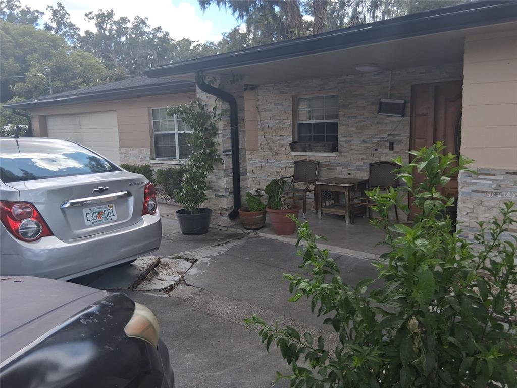 A silver car is parked in front of a house with a stone-veneer porch — 702 COULTER PLACE, BRANDON, FL