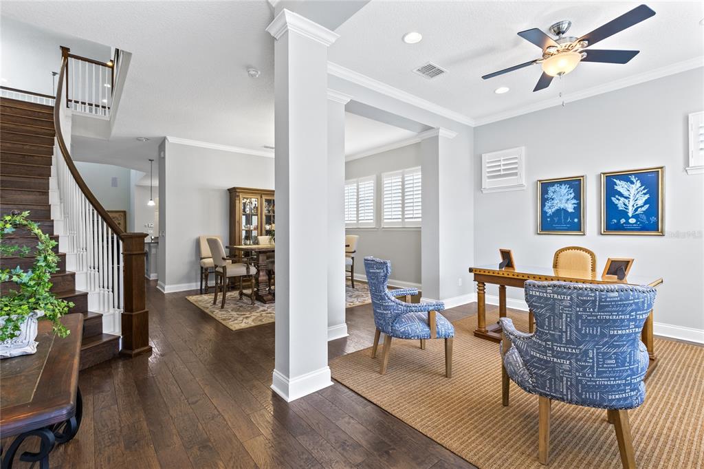 A home office area with a desk and patterned chairs sits beside a dining room — 8539 MARTINSON STREET, ORLANDO, FL