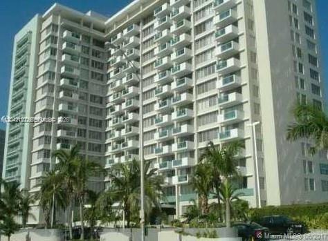 A tall white residential apartment building with many balconies surrounded by palm trees — 1000 WEST AVE # 318, Miami Beach FL 33139, MIAMI BEACH, FL