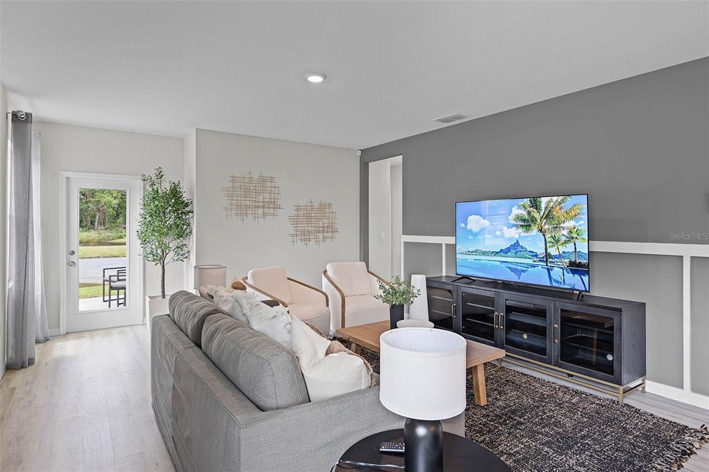 A living room features a gray sofa, two armchairs, and a television on a console — 4948 KAIA, WINTER HAVEN, FL