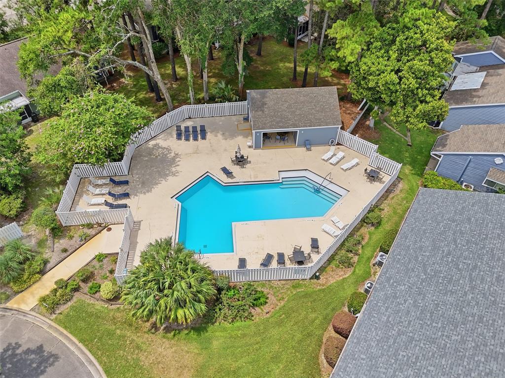 An aerial view shows a swimming pool with a surrounding patio, lounge chairs, and clubhouse — 1022 NW 125TH DRIVE, NEWBERRY, FL