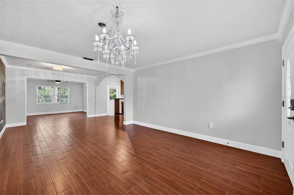 A dining room with wood-look tile flooring, a crystal chandelier, and light gray walls — 1009 LAKE BELL DRIVE, WINTER PARK, FL