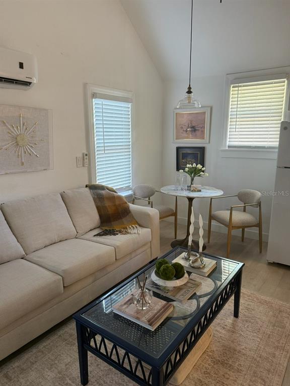 A living room features a light-colored sofa, a glass-top coffee table, and a small dining area — 305 MARY AVENUE, NEW SMYRNA BEACH, FL