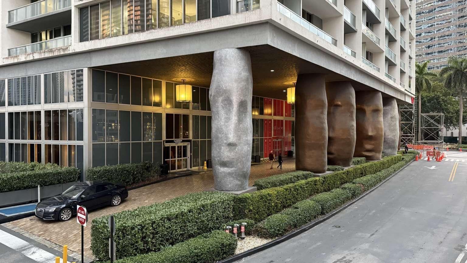 The exterior of a modern building features large, sculptural columns shaped like human faces — 485 Brickell Avenue # 3608, Miami FL 33131, MIAMI, FL