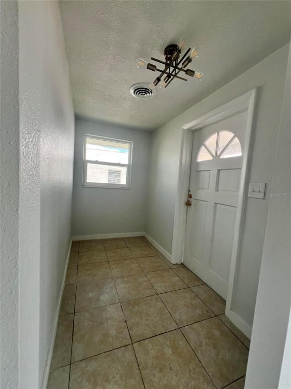 A small entryway features light-colored tile flooring, a white door, and a modern ceiling light — 744 LEMON AVENUE, SEBRING, FL