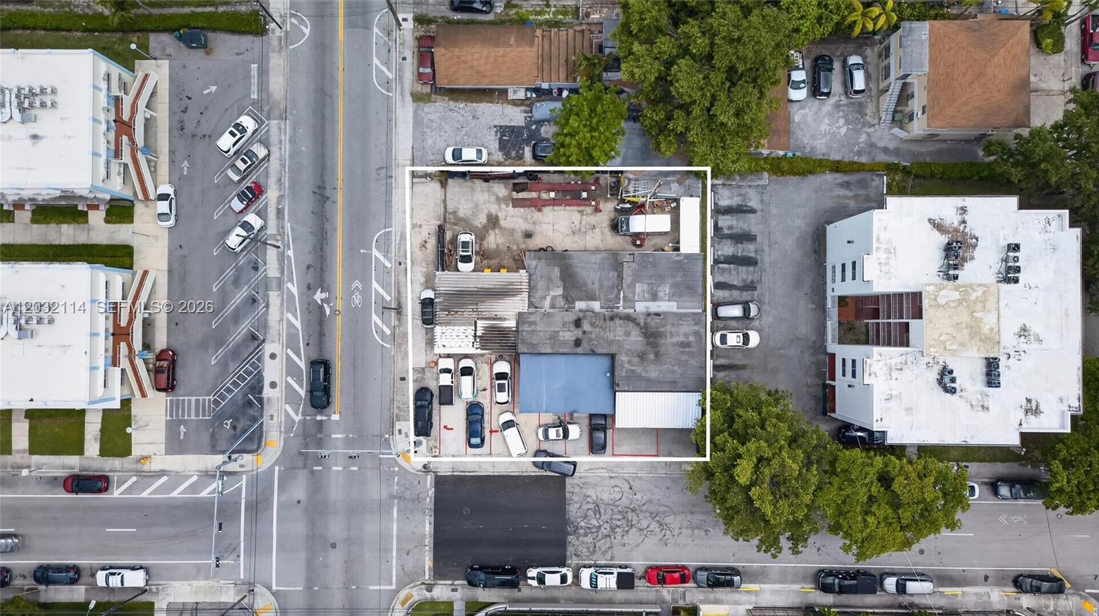 An aerial view shows a commercial property with a building and parking lot — MIAMI, FL