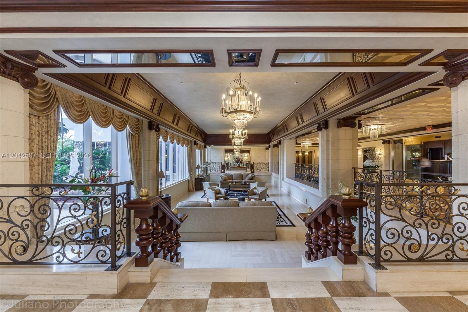 A grand, formal living area features ornate chandeliers, dark wood trim, and decorative iron railings — 2030 S Ocean Dr # 412, Hallandale Beach FL 33009, HALLANDALE BEACH, FL